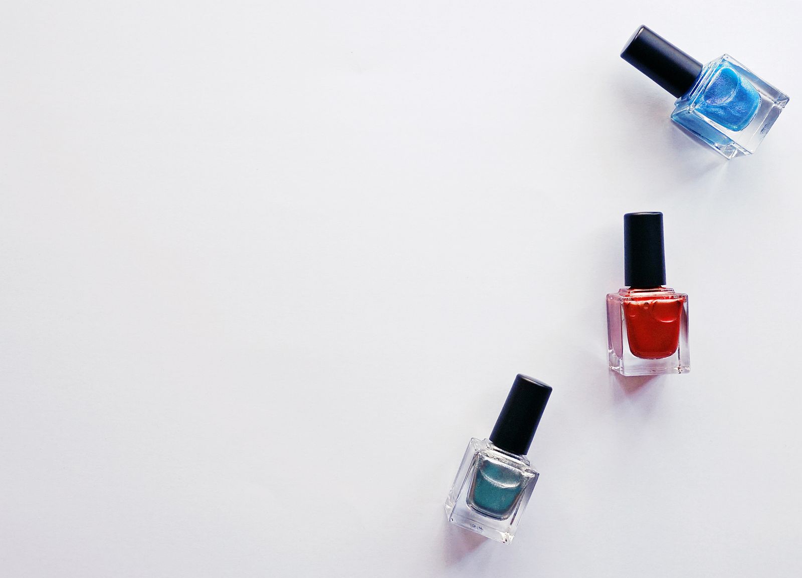 A bright trio of red, blue and teal nail polishes