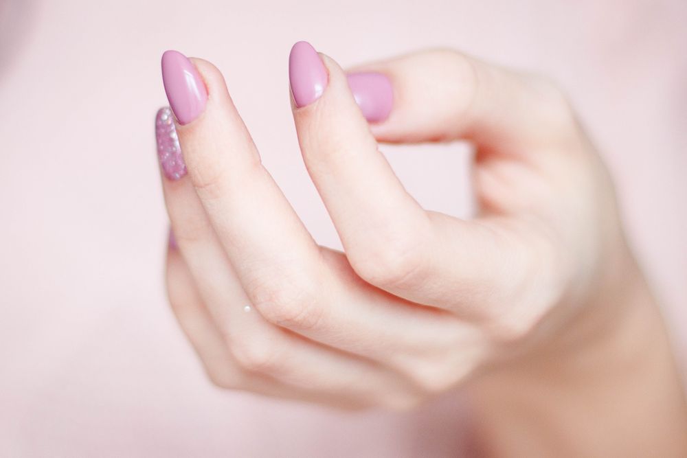 Pink nails with a glitter accent, shown in close-up