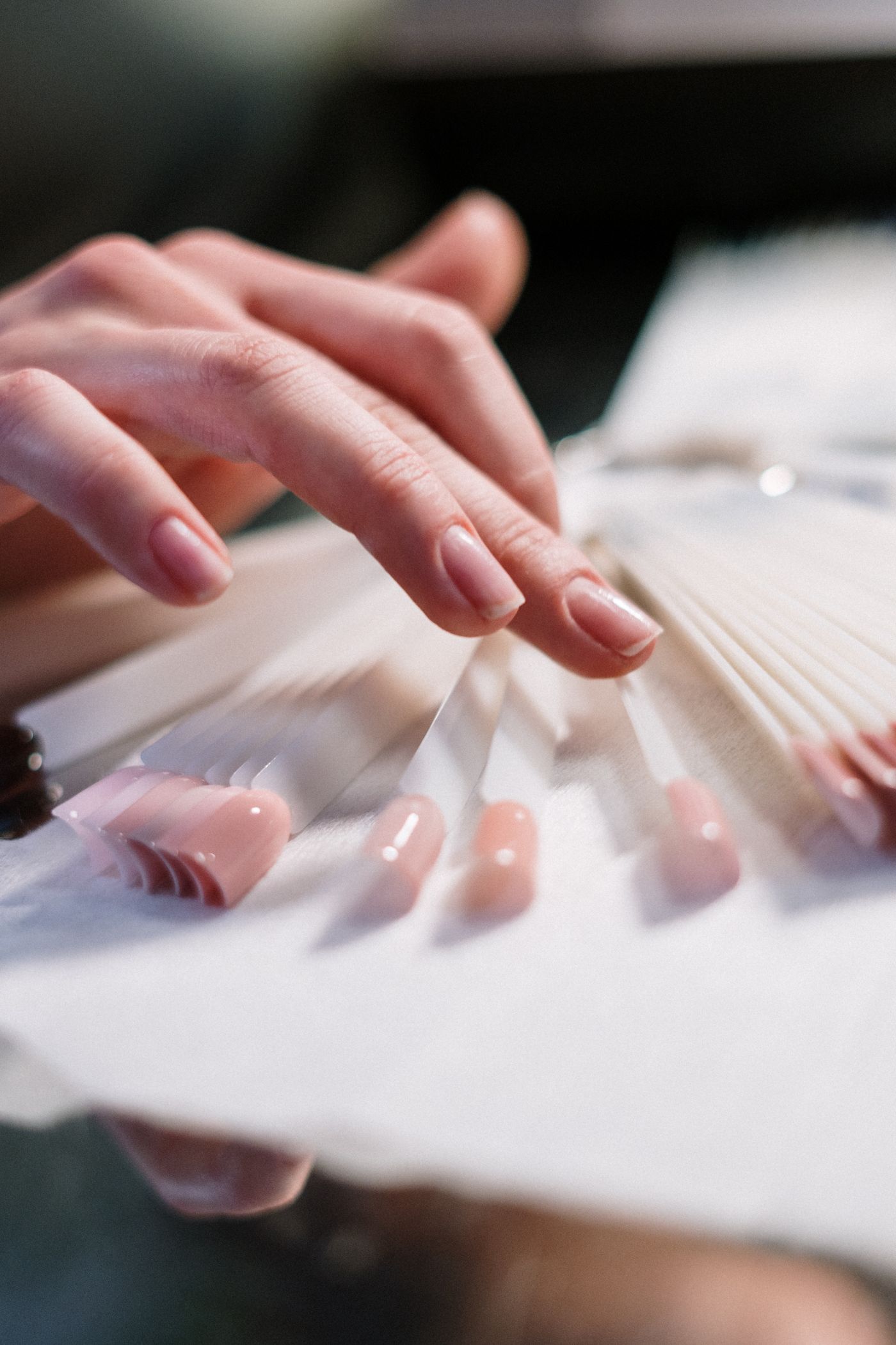A hand choosing from a palette of delicate nail colors